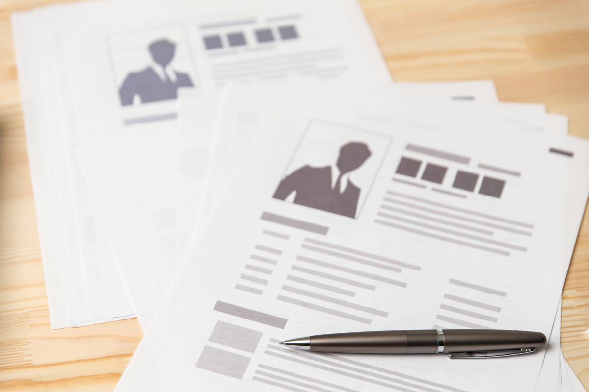 Documents avec silhouettes de portraits et stylo sur une table en bois