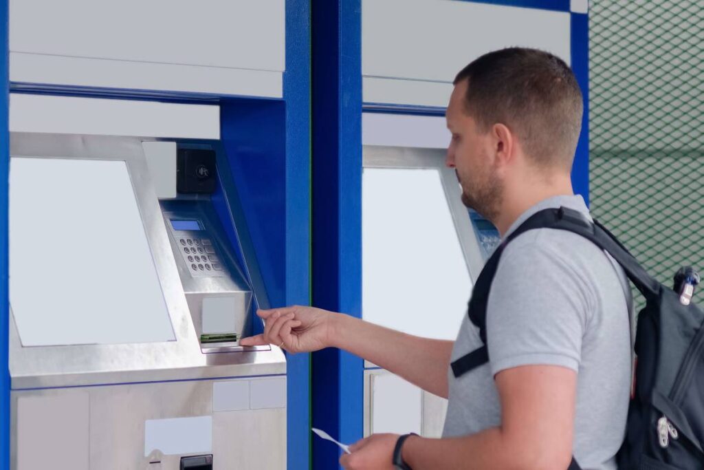 Un étudiant qui est éligible à la bourse, en train de tirer le montant de son aide financière.