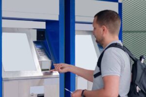 Un étudiant qui est éligible à la bourse, en train de tirer le montant de son aide financière.